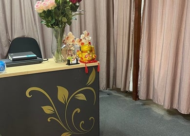 Reception at Magic Touch Thai Massage, The Rocks, New South Wales, AU with floral decor and lucky cat statue.