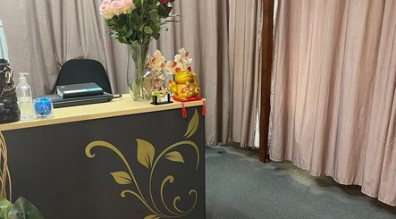 Reception at Magic Touch Thai Massage, The Rocks, New South Wales, AU with floral decor and lucky cat statue.