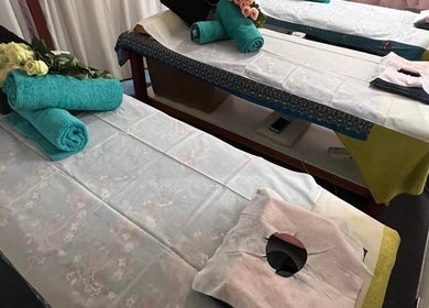 Massage beds at Magic Touch Thai Massage, The Rocks, New South Wales, AU, adorned with towels and flowers.