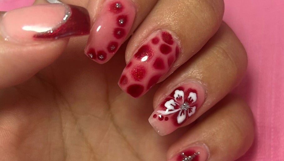 Elegant floral nail design at Beauty Lounge by Isabelle, Penygroes, Wales, GB showcasing red and white tones.