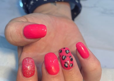 Vibrant pink nail art at Beauty Lounge by Isabelle in Penygroes, Wales, GB, showcasing glitter and leopard patterns.