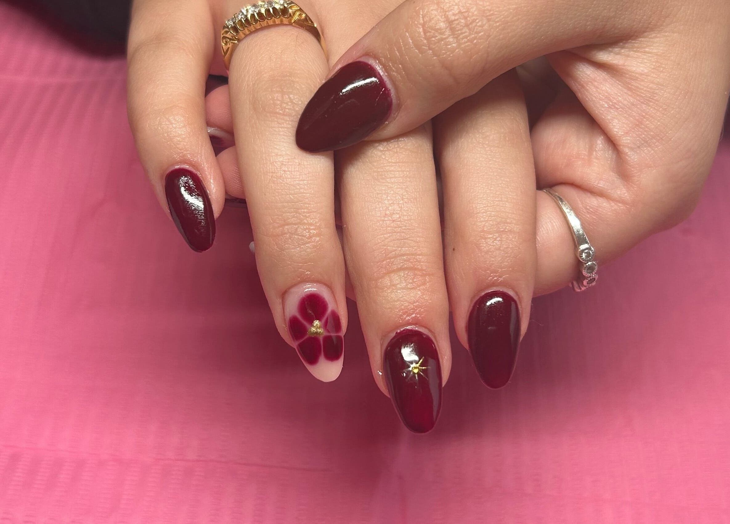Stylish burgundy nail art at Beauty Lounge by Isabelle, Penygroes, Wales, GB showcasing flower design.