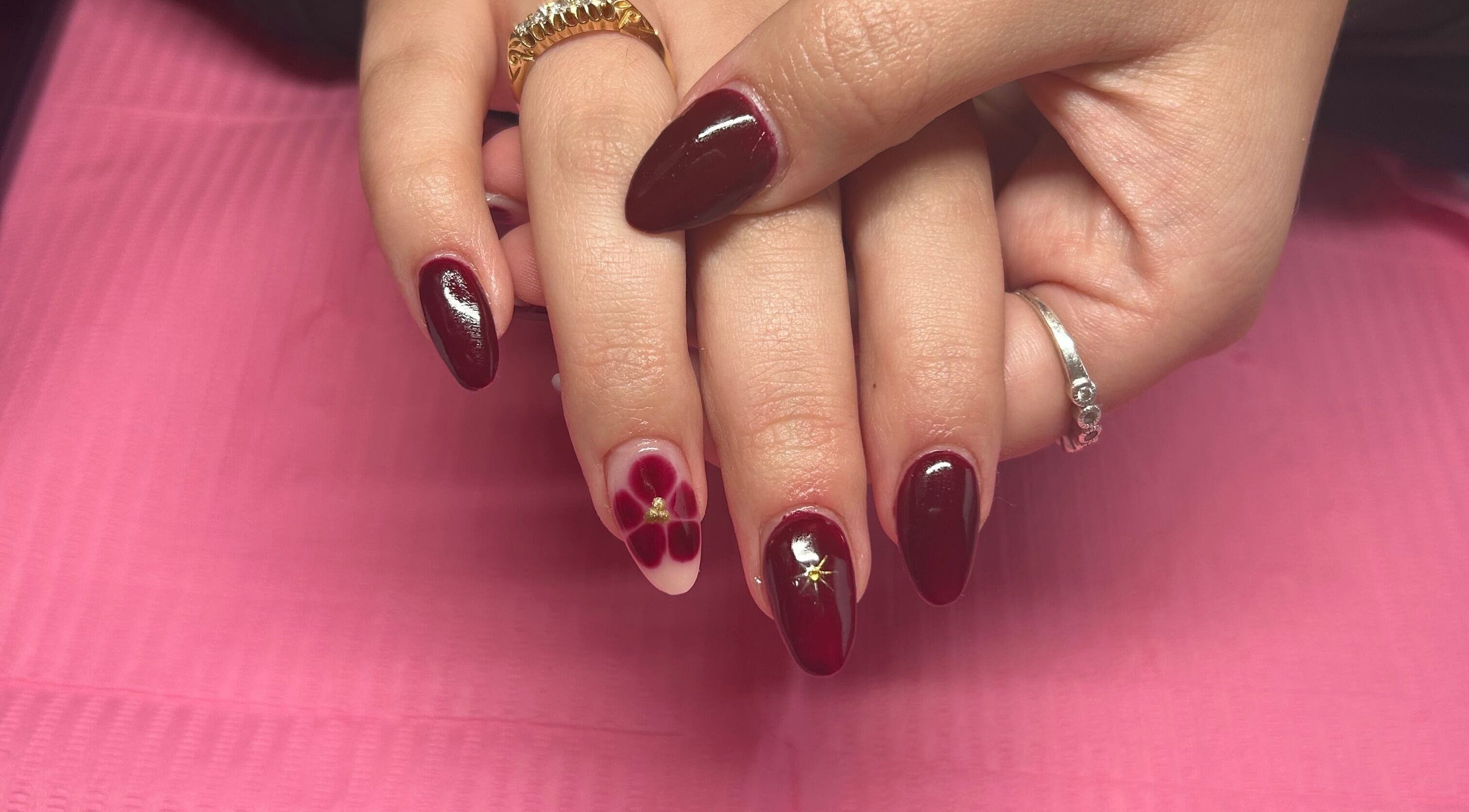 Stylish burgundy nail art at Beauty Lounge by Isabelle, Penygroes, Wales, GB showcasing flower design.