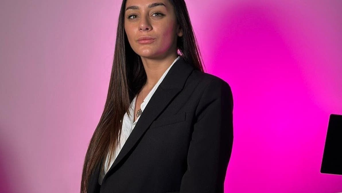 Professional individual at Simona Minov, San Ġwann, MT in a sleek black blazer against a pink backdrop.
