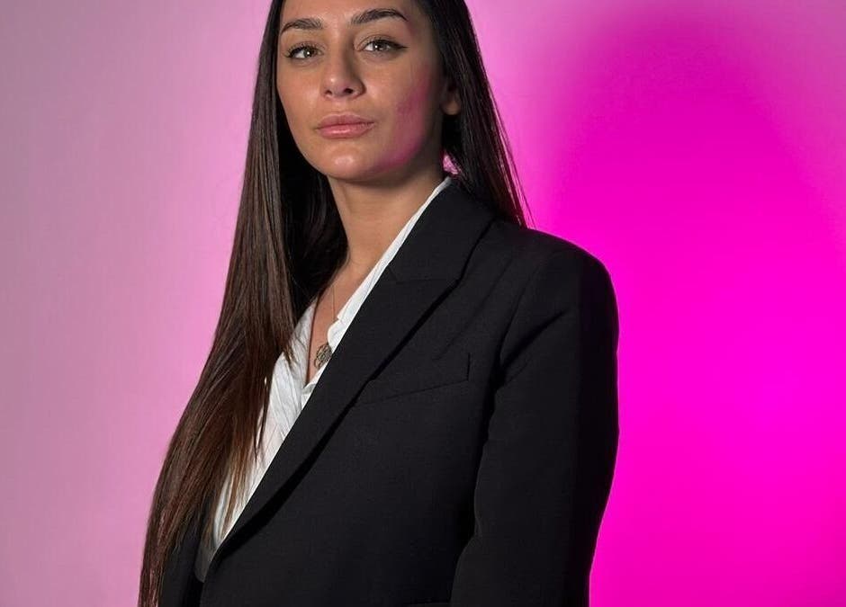 Professional individual at Simona Minov, San Ġwann, MT in a sleek black blazer against a pink backdrop.
