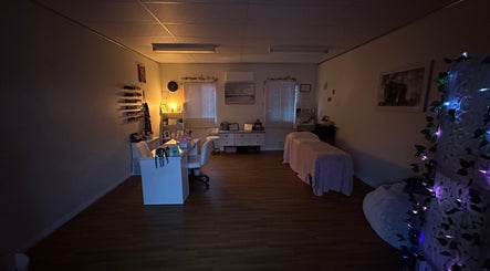 Relaxing treatment room at Dollhaven_co, Walmsley, Western Australia, AU, featuring ambient lighting and comfortable beds.