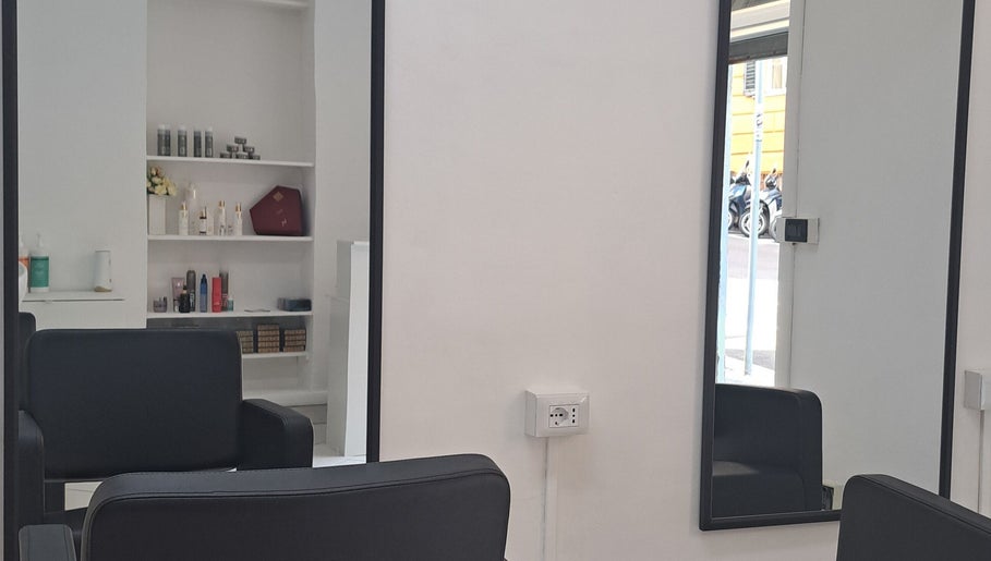Interno moderno di Studio 7 a Genova, Liguria, IT con specchio e sedie eleganti.
