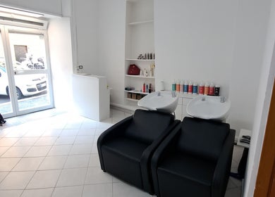 Interno di Studio 7, Genova, Liguria, IT con poltrone nere e lavatesta in ambiente luminoso.
