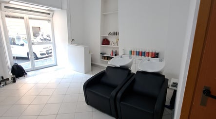 Interno di Studio 7, Genova, Liguria, IT con poltrone nere e lavatesta in ambiente luminoso.