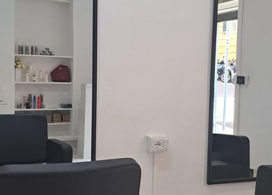 Interno moderno di Studio 7 a Genova, Liguria, IT con sedie eleganti e scaffali di prodotti.