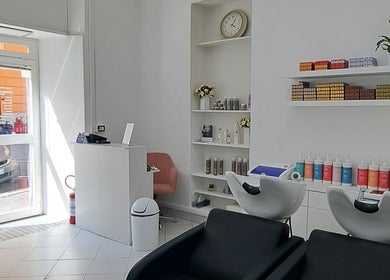 Interno elegante di Studio 7 in Genova, Liguria, IT con sedie e prodotti per la bellezza.
