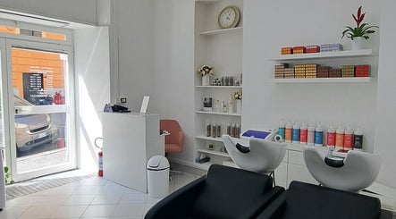 Interno elegante di Studio 7 in Genova, Liguria, IT con sedie e prodotti per la bellezza.