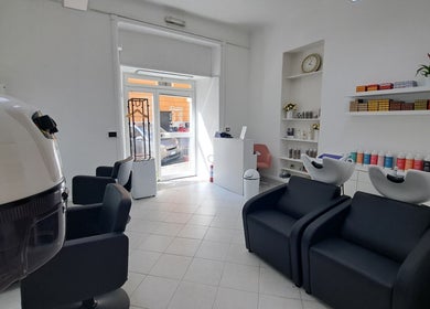 Interno elegante di Studio 7 a Genova, Liguria, IT, con sedie nere e prodotti di bellezza.