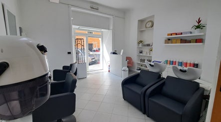 Interno elegante di Studio 7 a Genova, Liguria, IT, con sedie nere e prodotti di bellezza.