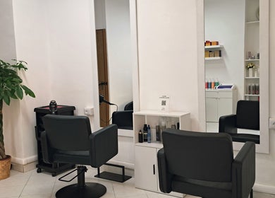 Postazione di lavoro elegante presso Studio 7 a Genova, Liguria, IT con specchi e sedie moderne.