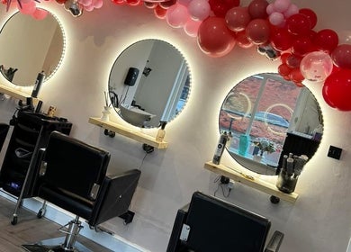 Stylish salon interior at No3 Hair & Beauty, Worsley, England, GB featuring round lit mirrors and chic decor.