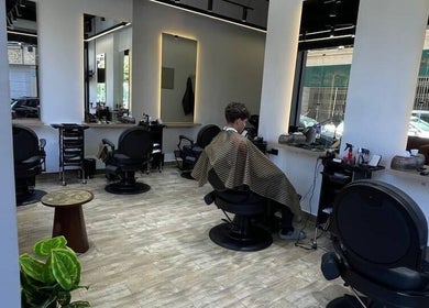 Modern interior of Mohamed Gaber Salon in Alexandria Governorate, EG, showcasing stylish barber chairs and mirrors.