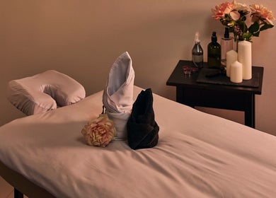 Relaxing massage table setup at Hands Of Celia, Abu Dhabi, Abu Dhabi, AE, with candles and flowers.