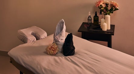 Relaxing massage table setup at Hands Of Celia, Abu Dhabi, Abu Dhabi, AE, with candles and flowers.