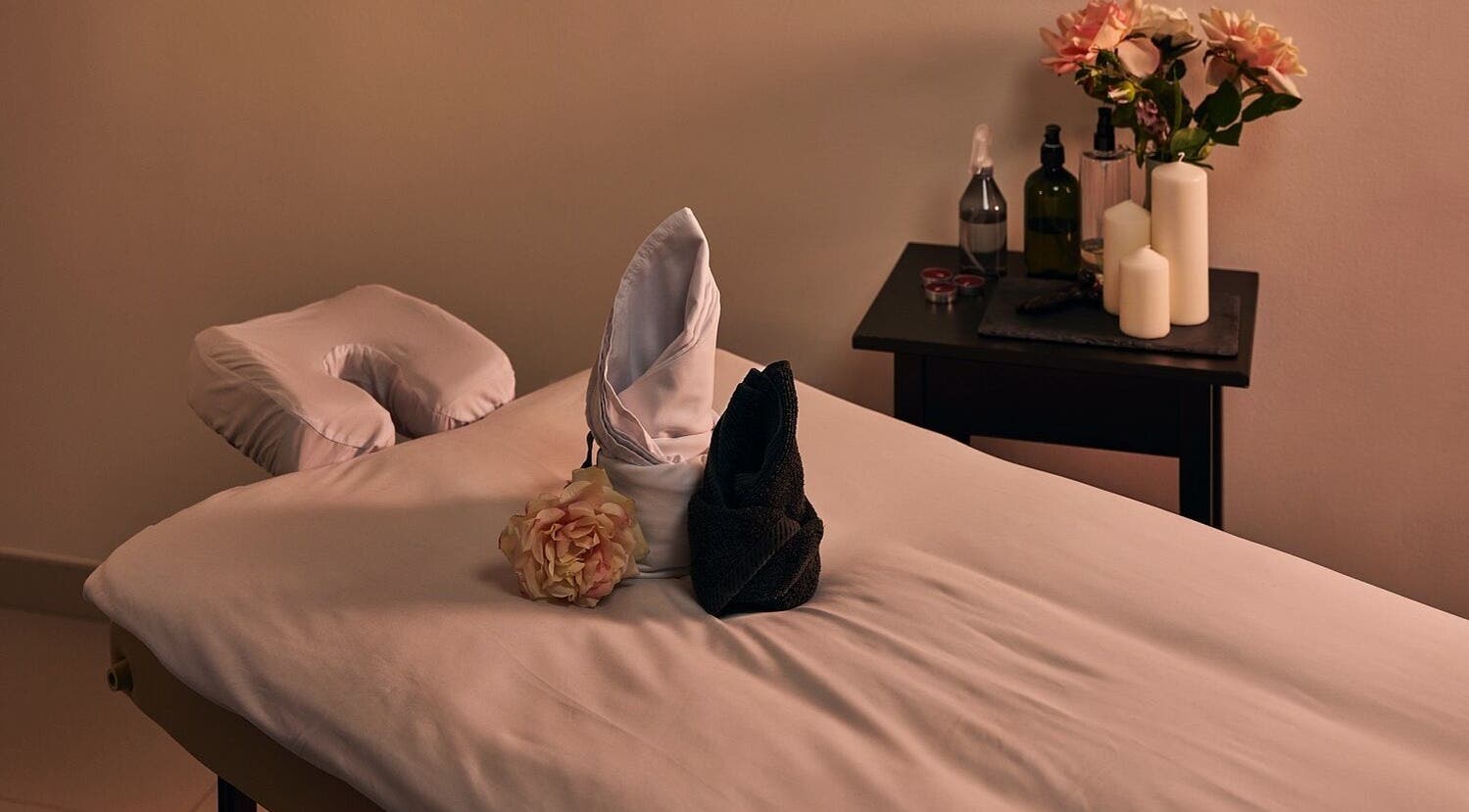Relaxing massage table setup at Hands Of Celia, Abu Dhabi, Abu Dhabi, AE, with candles and flowers.
