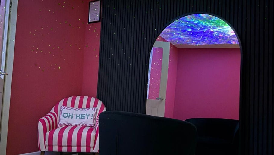 Bright pink and black themed room with striped chair at Eden’s Retreat, Glenfield, England, GB.