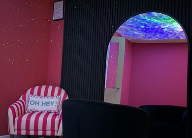 Bright pink and black themed room with striped chair at Eden’s Retreat, Glenfield, England, GB.