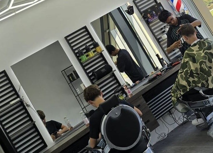 Interieur van Dimma The Barber in Zoetermeer, Zuid-holland, NL met kapper aan het werk.