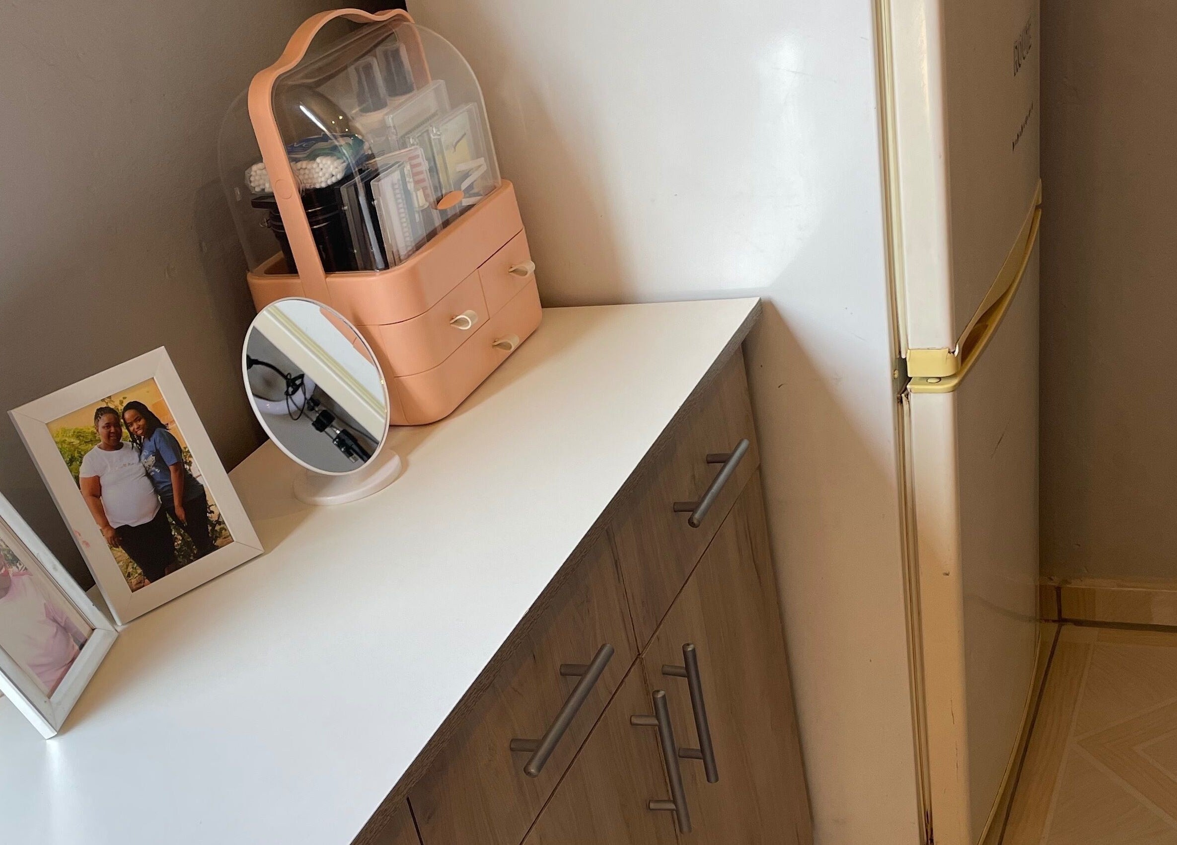 Vanity setup at KgoCgadi’s Beauty and Aesthetics, Carletonville, Gauteng, ZA with framed photos and a mirror.