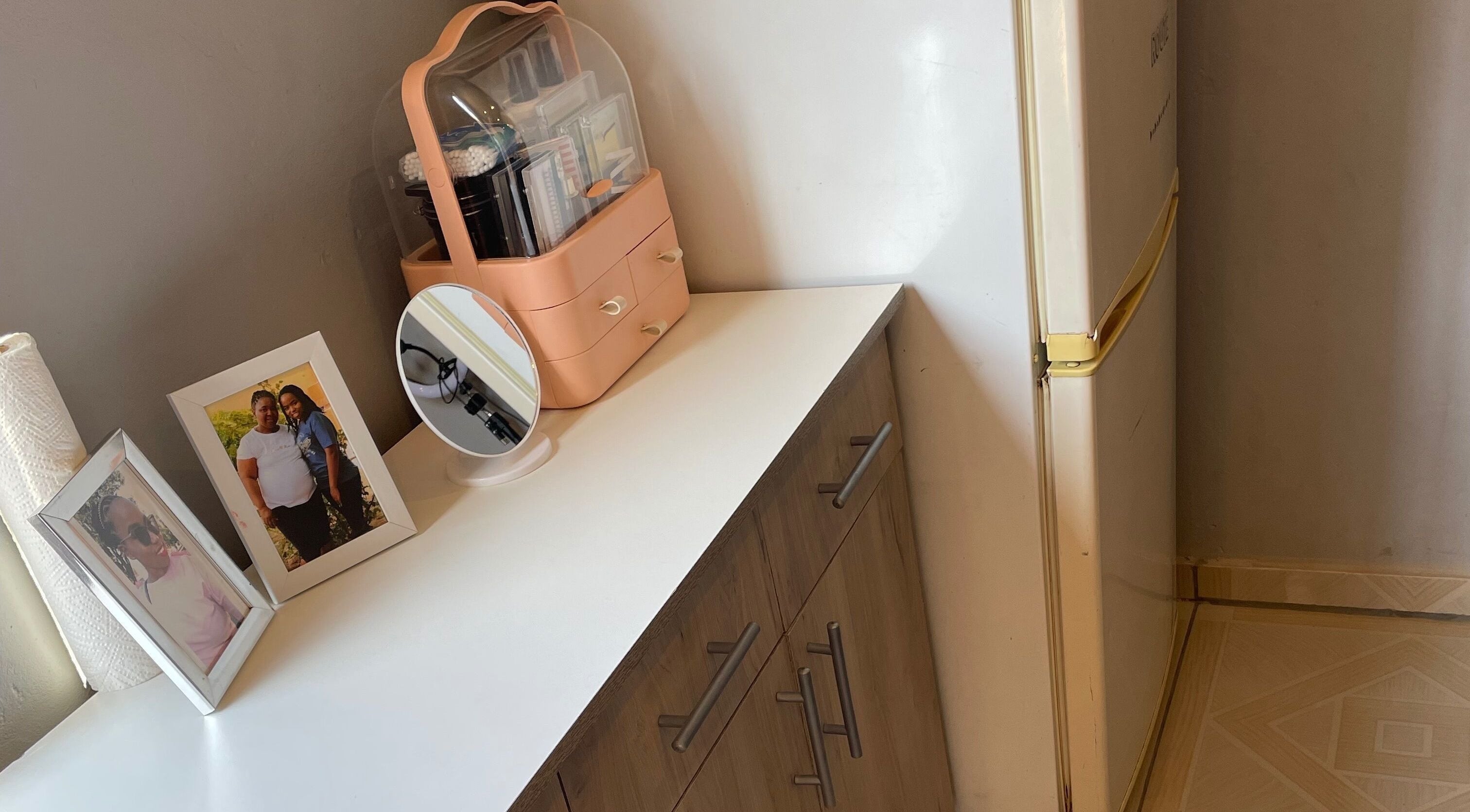 Vanity setup at KgoCgadi’s Beauty and Aesthetics, Carletonville, Gauteng, ZA with framed photos and a mirror.