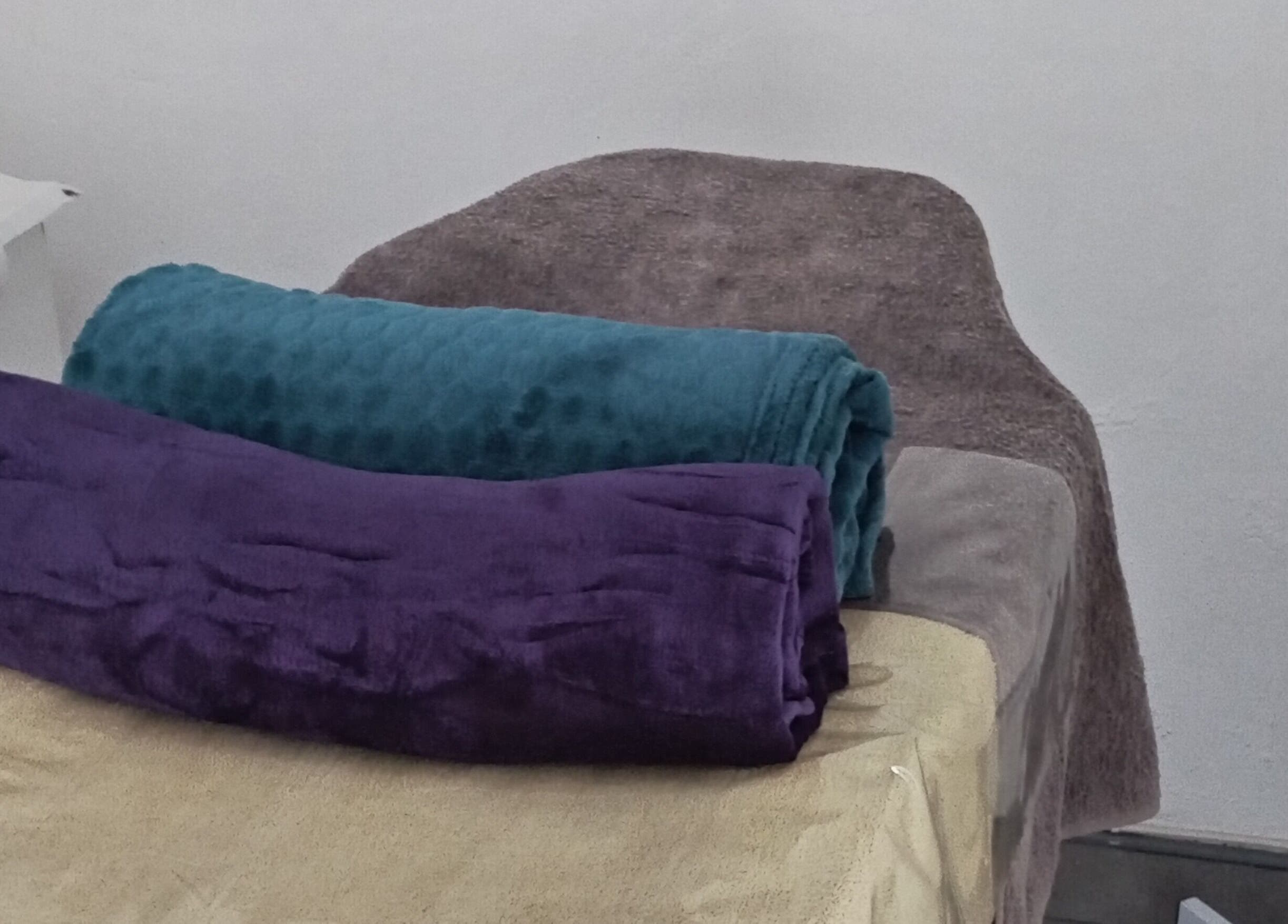 Plush towels on a treatment bed at Classic Nails and Beauty Salon by Chichi in Randburg, Gauteng, ZA.