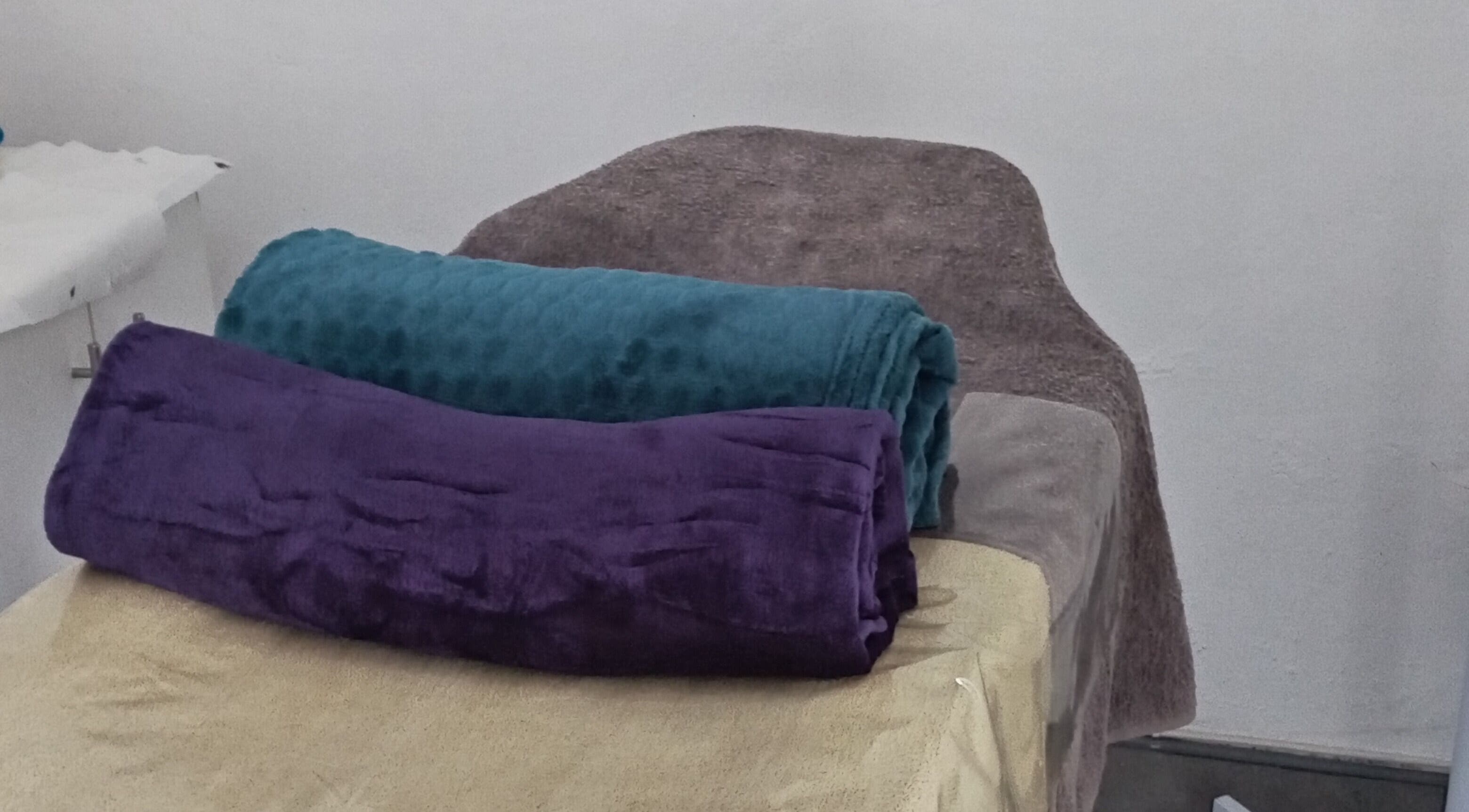 Plush towels on a treatment bed at Classic Nails and Beauty Salon by Chichi in Randburg, Gauteng, ZA.