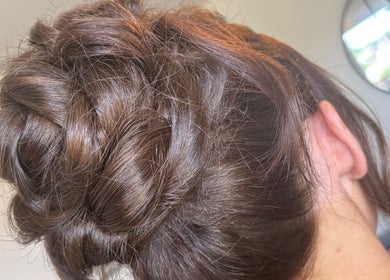 Intricate updo hairstyle at Hair Up by Em, Birmingham, England, GB. Showcases smooth brown hair design.