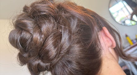 Intricate updo hairstyle at Hair Up by Em, Birmingham, England, GB. Showcases smooth brown hair design.