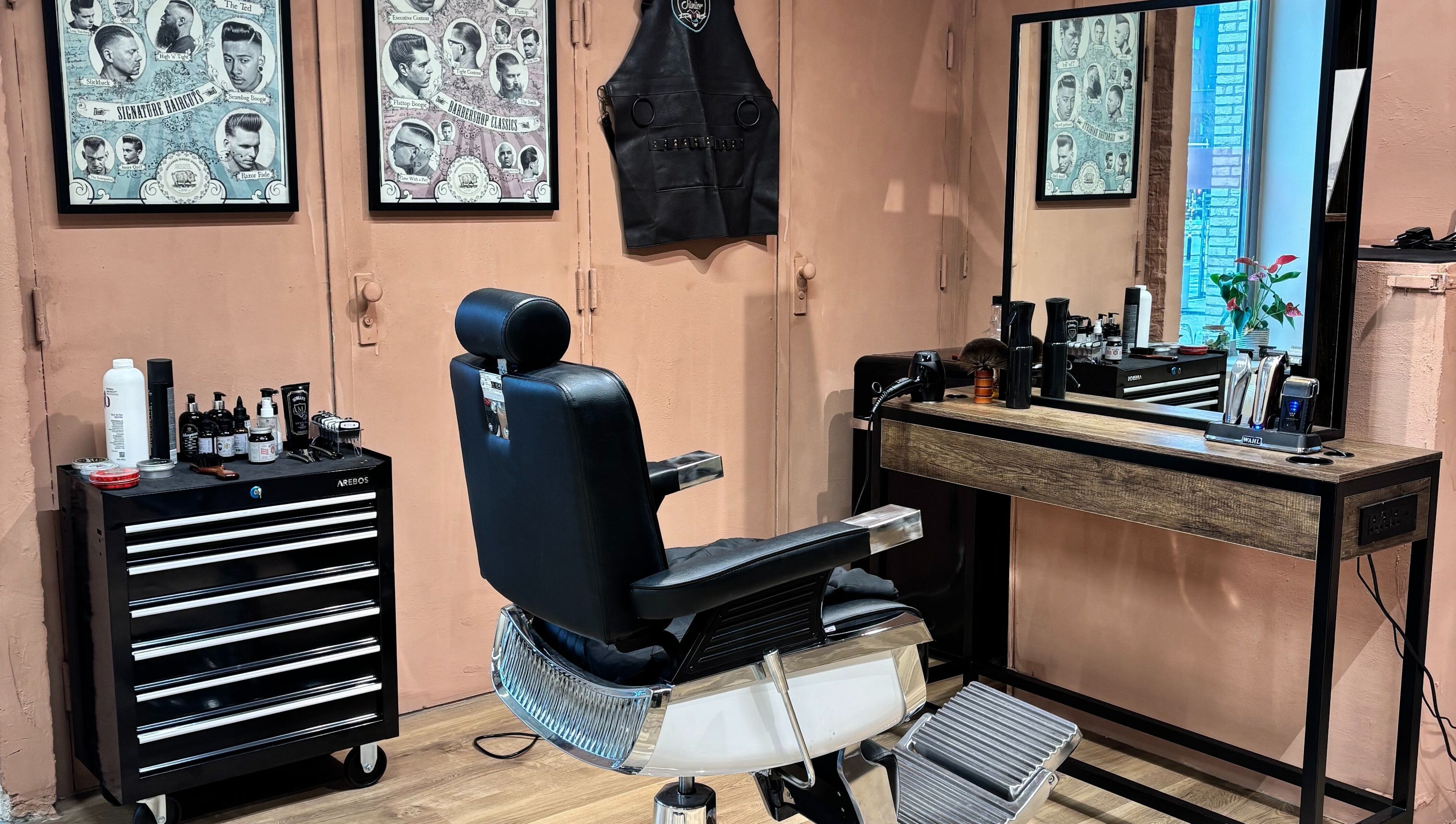 Interior da Assis Junior Barber em Eindhoven, Noord-brabant, NL. Cadeira de barbeiro e espelho elegante.