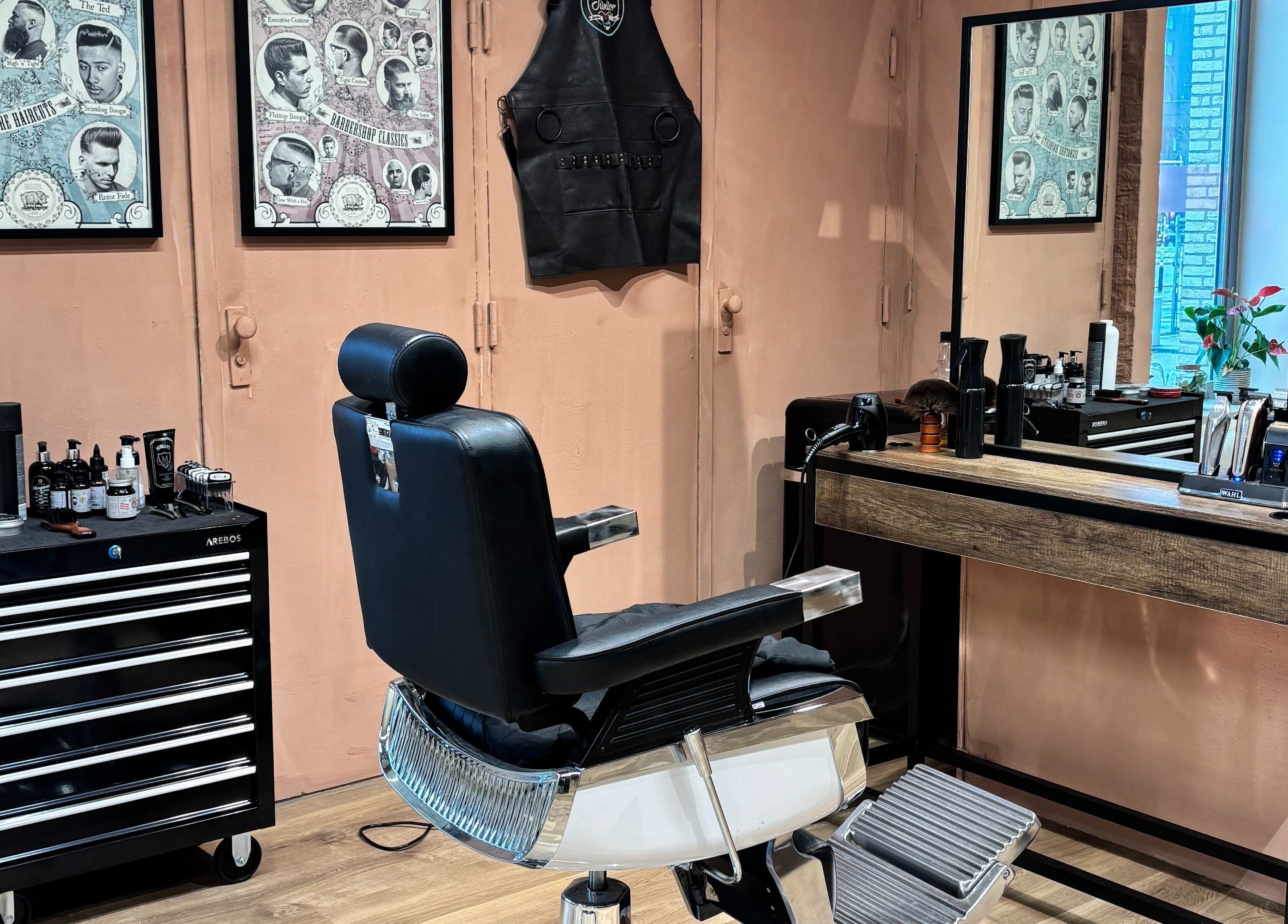Interior da Assis Junior Barber em Eindhoven, Noord-brabant, NL. Cadeira de barbeiro e espelho elegante.