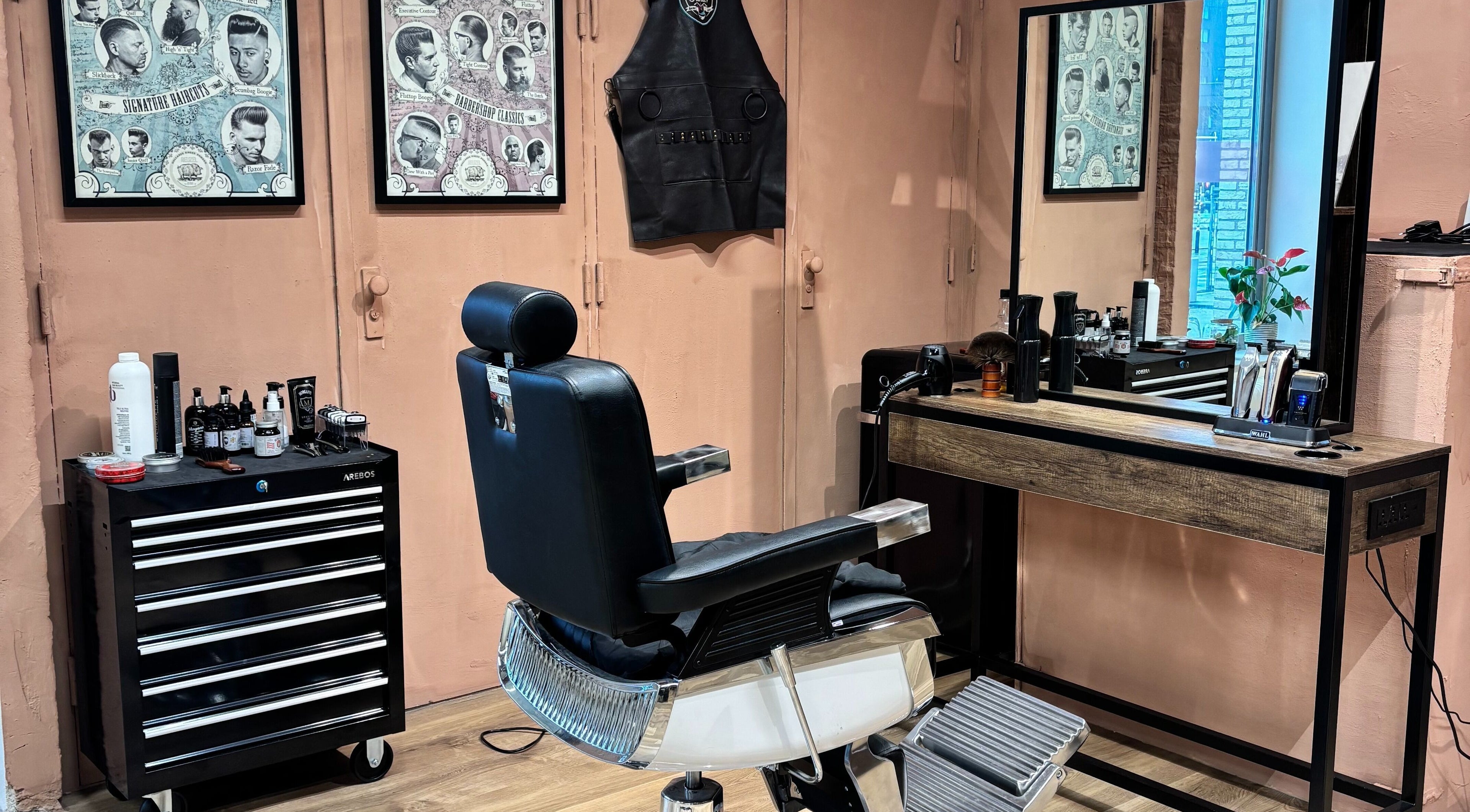 Interior da Assis Junior Barber em Eindhoven, Noord-brabant, NL. Cadeira de barbeiro e espelho elegante.