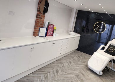 Interior of Emma Johnstone Medical Aesthetics in Wigan, England, featuring sleek white décor and treatment chair.