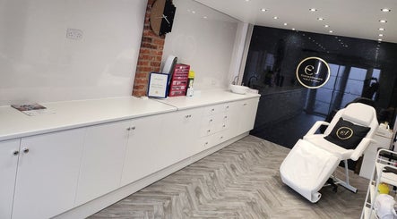 Interior of Emma Johnstone Medical Aesthetics in Wigan, England, featuring sleek white décor and treatment chair.