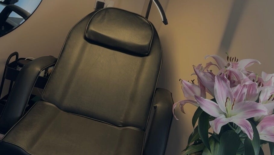 Cozy leather chair and fresh lilies at Blush Studios, Leicester, England, GB, creating a serene ambiance.