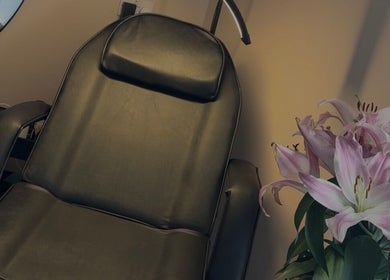 Cozy leather chair and fresh lilies at Blush Studios, Leicester, England, GB, creating a serene ambiance.