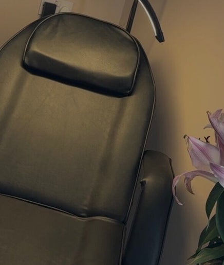 Cozy leather chair and fresh lilies at Blush Studios, Leicester, England, GB, creating a serene ambiance.