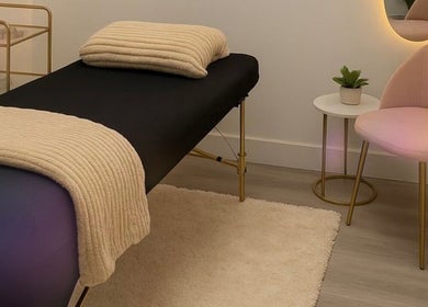 Relaxing treatment room at Wax & Glow Studio, Allentown, Pennsylvania, US with cozy massage table and plush chair.