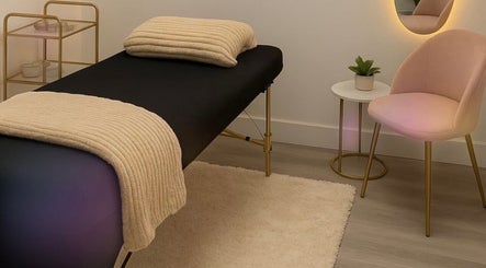 Relaxing treatment room at Wax & Glow Studio, Allentown, Pennsylvania, US with cozy massage table and plush chair.
