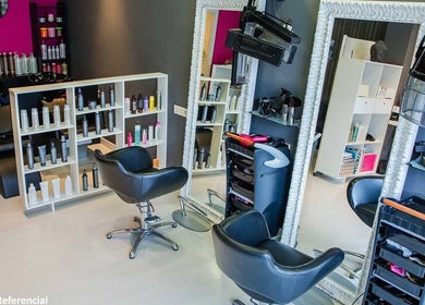 Interior moderno de Black Parade Studio en Concepción, Bío Bío, CL, con sillas elegantes y productos de belleza.