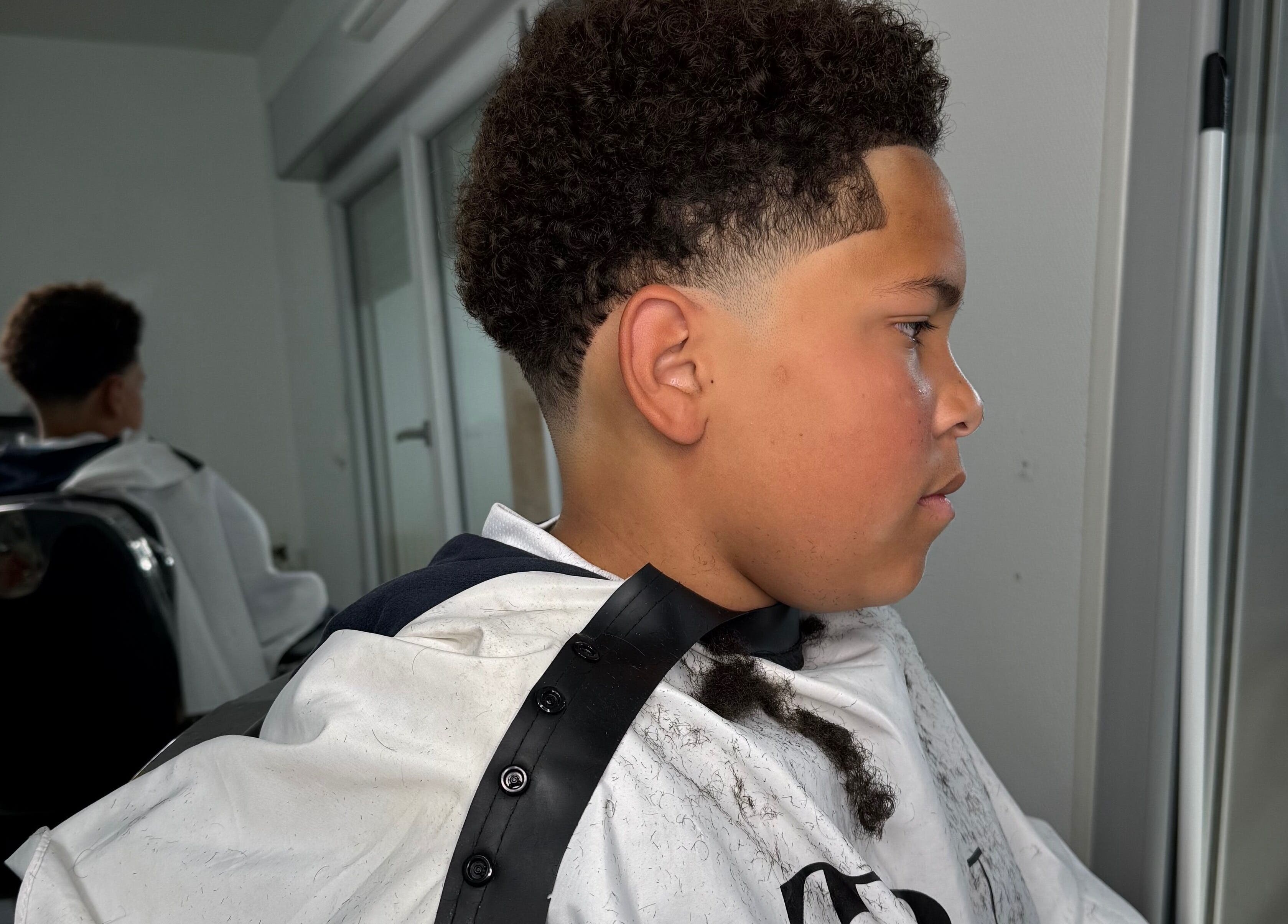 Jeune garçon avec coupe dégradée chez YP Studio Barber, Châteaubriant, Pays De La Loire, FR.
