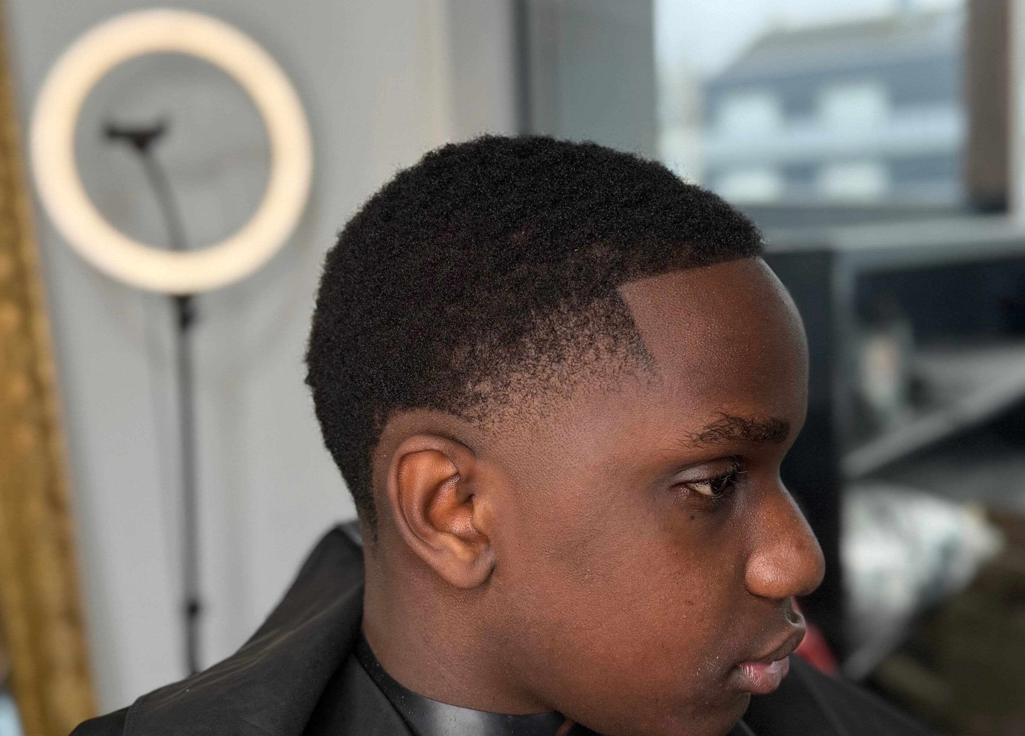 Coiffure moderne chez YP Studio Barber, Châteaubriant, Pays De La Loire, FR, avec un jeune homme stylé.