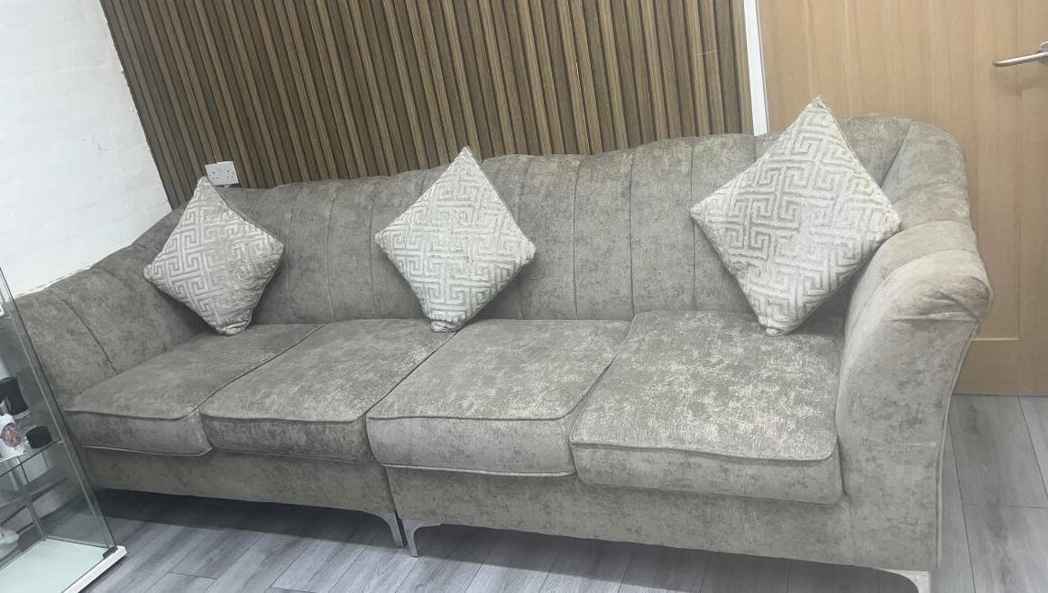 Elegant grey sofa with patterned pillows at Melissa Harper Hairdressing, Liverpool, England, GB.