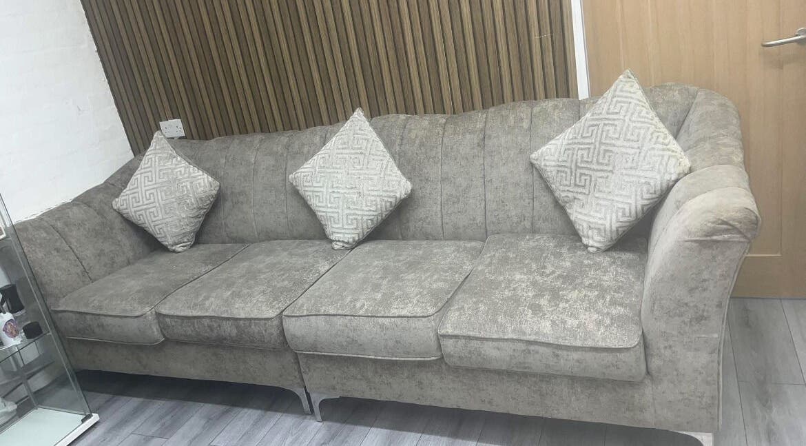 Elegant grey sofa with patterned pillows at Melissa Harper Hairdressing, Liverpool, England, GB.