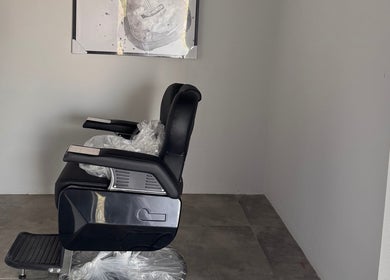 Modern barber chair at Mr Boombastic in Sib, Muscat Governorate, OM. Sleek design in a minimalist setting.