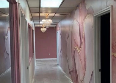 Elegant marble hallway at Beaute Kam Hair in Monroe, Louisiana, US, with chandeliers and pink decor.